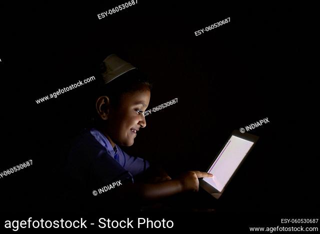 A boy happily watching tablet at home