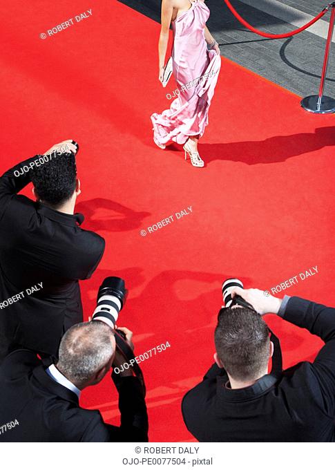 Celebrity walking for paparazzi on red carpet