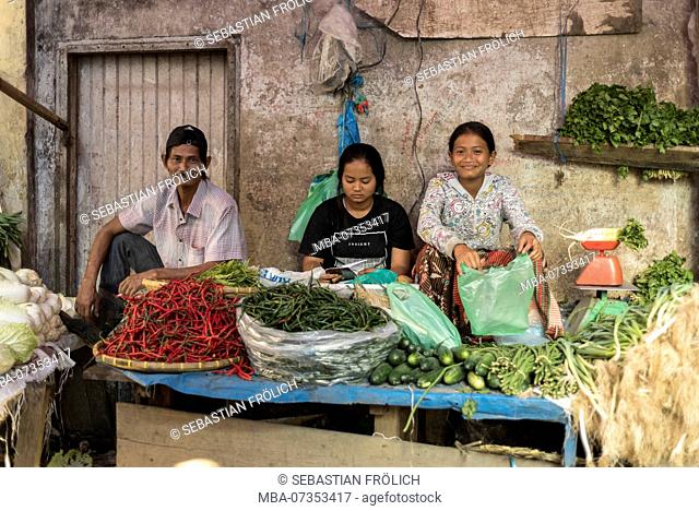 A family selling vegetables at their market stall