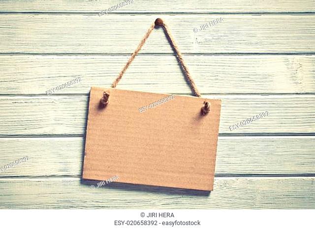 paper board hanging on wooden wall
