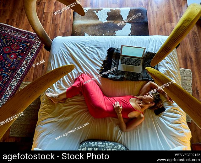 Woman relaxing on bed in hotel room