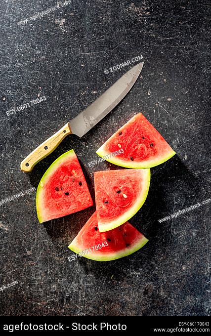 Red sliced watermelon. Pieces of red melon on black table. Top view
