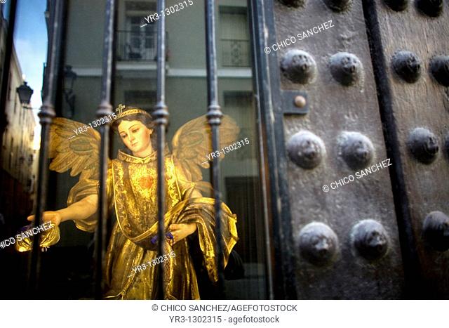A statue of Saint Raphael Arcangel sits behind a window as the city of Cadiz is reflected in Andalusia, Spain, April 17, 2010
