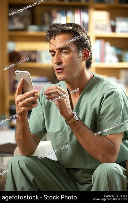 Hispanic Male doctor practicing tele-medicine from his home office, Talking to patient on video call