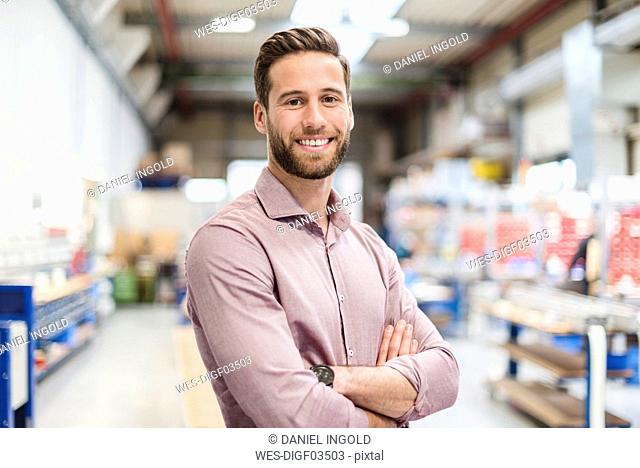 Smiling businessman in production hall