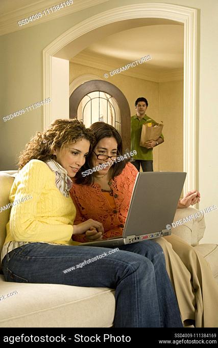 Women using laptop in living room