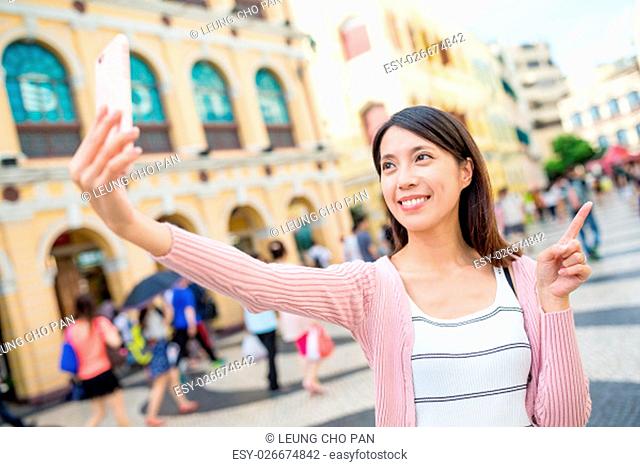 Asian woman using mobile phone to take self image