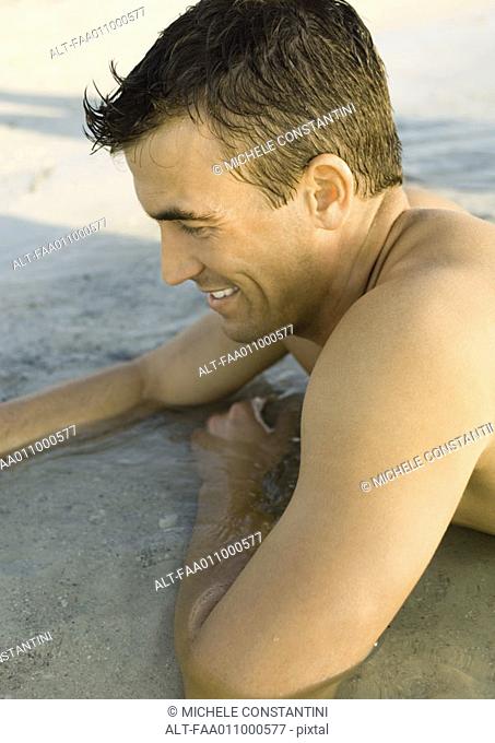 Man lying in shallow water