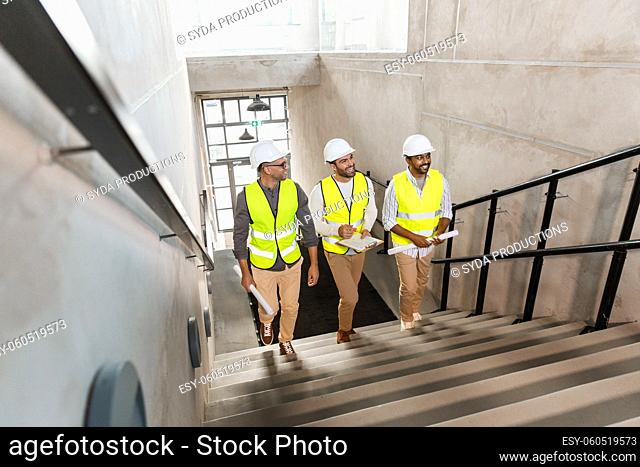 architects in helmets walking upstairs at office