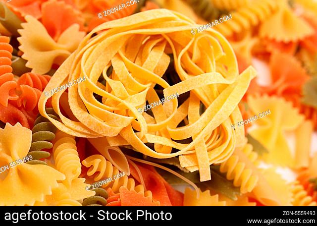 Yellow tagliatelle paglia e fieno on the backgroun of different pastas