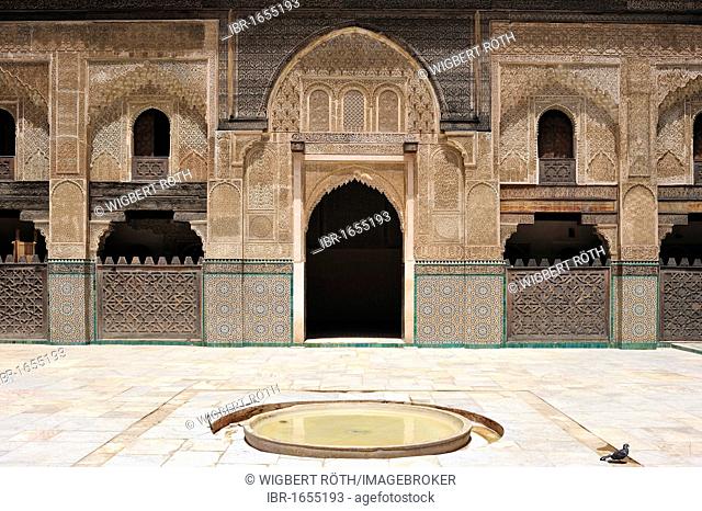 Courtyard of the Medersa Bou Inania with wash fountain, walls and arches decorated with cedar wood carvings, stucco ornaments and tile mosaics, Fes, Morocco