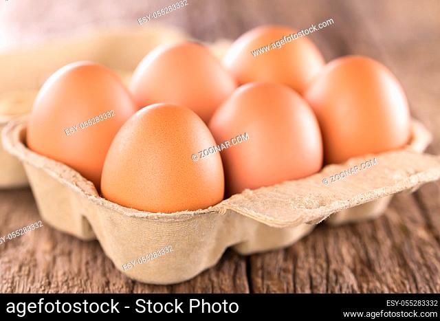 Raw brown eggs in egg box or carton (Very Shallow Depth of Field, Focus on the front of the first egg)