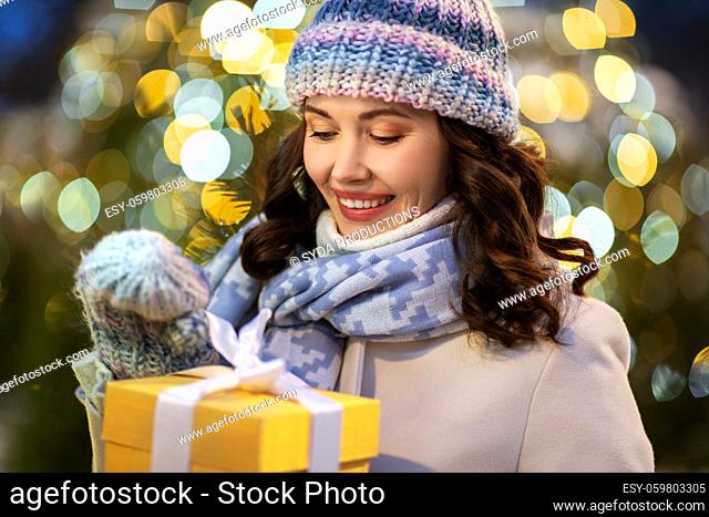 happy woman with christmas gift over lights