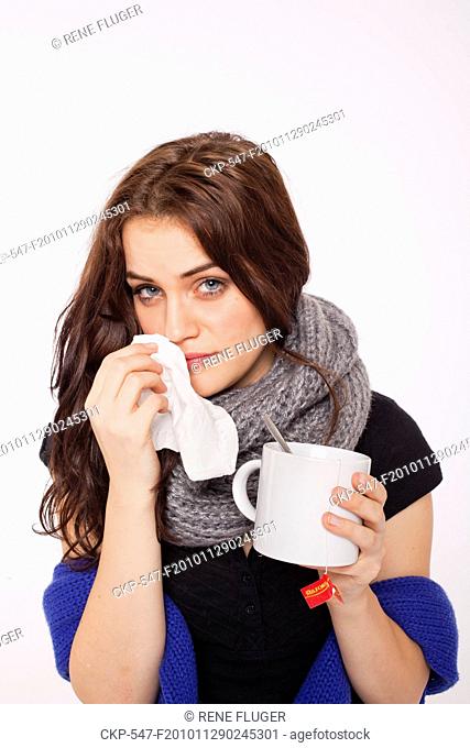 A beautiful young woman, lady, girl, cold, runny nose, headache, tissues, paper hankies, cup of tea, scarf CTK Photo/Rene Fluger , MR