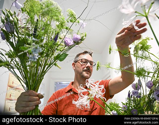 22 August 2023, Berlin: Florist Nicolaus Peters ties a bouquet of different flowers. He will be taking part in the World Cup of Florists in Manchester for...