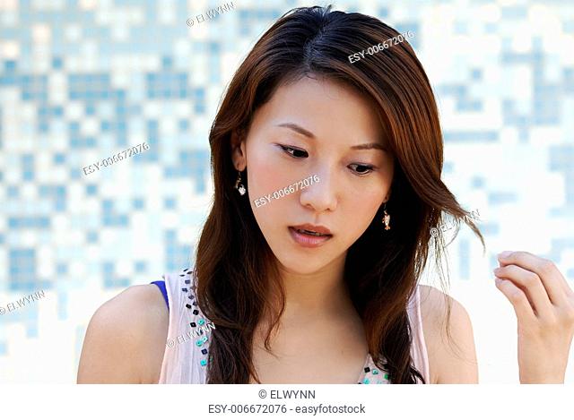 Here is a beautiful Asian lady in front of mosaic and watching