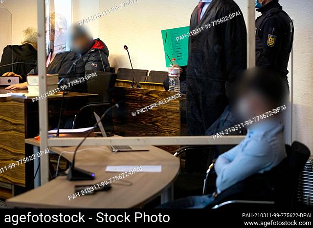 11 March 2021, Baden-Wuerttemberg, Freiburg: Three defendants are sitting in a courtroom at Freiburg Regional Court. The three men are alleged to have jointly...