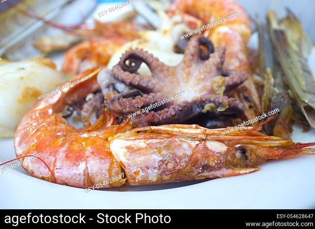 Assorted grilled seafood on plate. Closeup