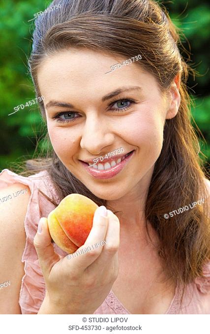 Young woman with a yellow peach