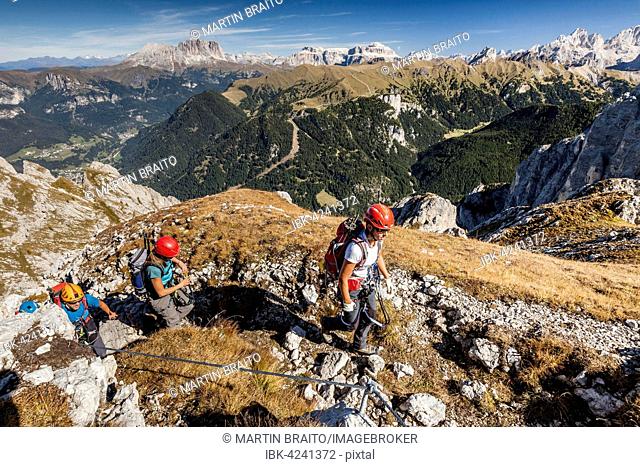 Mountaineer climbing the Cima Valacia on Via Ferrata cable, F. Gadotti in Val San Nicolo di Fassa, behind Langkofel and Plattkofel and the Sella Group