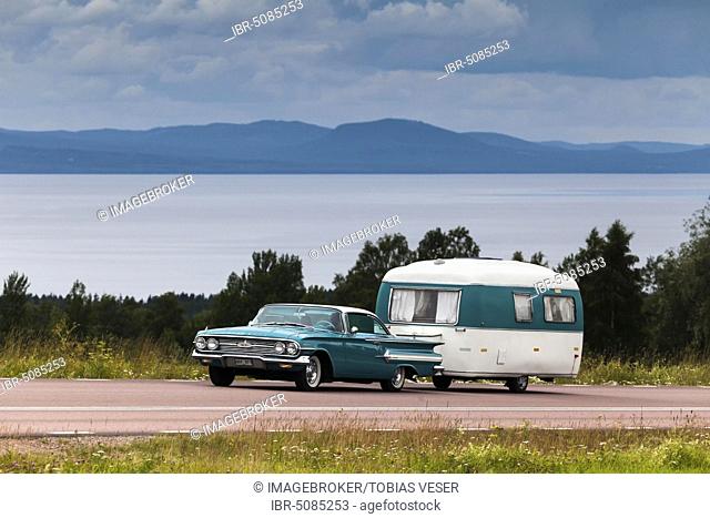 American classic car, Chevrolet Impala Coupe built 1960, with retro caravan, Lake Siljan at the back, near Rättvik, Dalarna, Sweden, Europe
