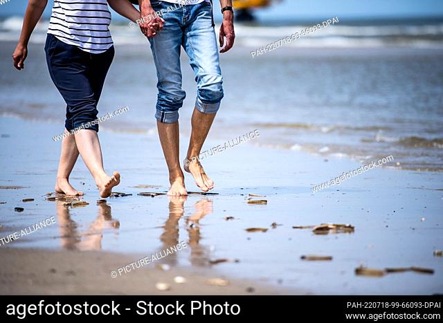 18 July 2022, Lower Saxony, Norderney: Tourists walk along the beach of the East Frisian islands of Norderney. Photo: Sina Schuldt/dpa