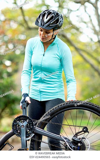 Fit woman repairing her bicycle