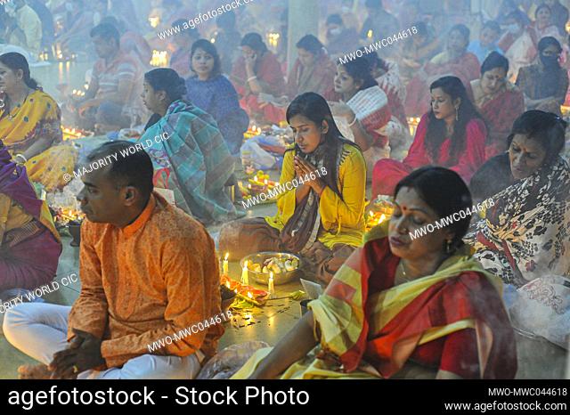 Devotees offer prayers during the ritual called Kartik Brati or Rakher Upobash with the lighting of oil lamps and candles, at the Lokonath Temple of Korer Para