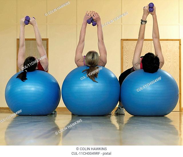women exercising with weights at gym