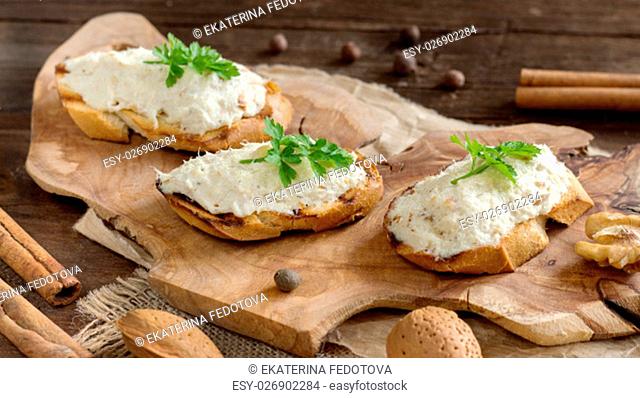 Toasted bread with a salted codfish mousse on wooden cutting board