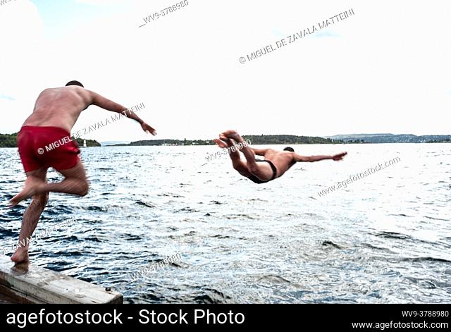 Two men jump happily and vigorously to the sea