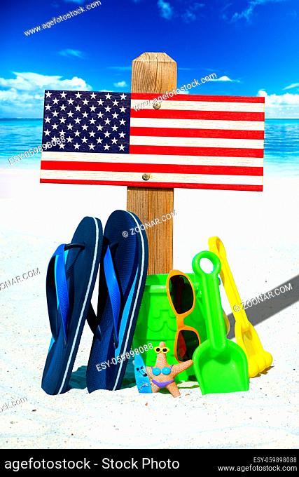 Holzschild mit USA Flagge am Strand