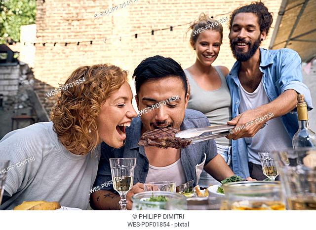 Friends having fun at a barbecue party, eating together