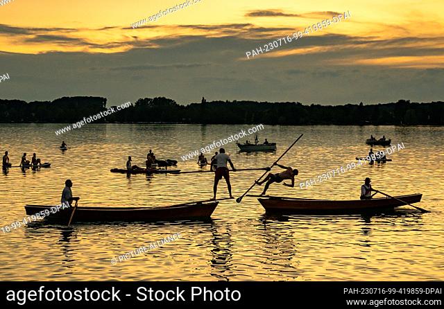 15 July 2023, Bavaria, Steinebach: Fisherman Thomas Aumiller (l) pushes his competitor Oliver Kaiser (r) into Lake Wörth during the finals for first place in...
