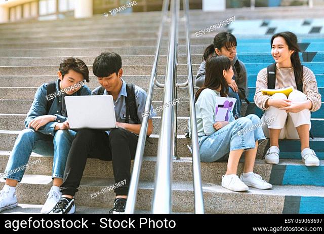 Happy Teenager Students talking and sitting On the Stairs