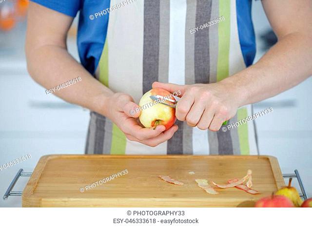 man peeling apple