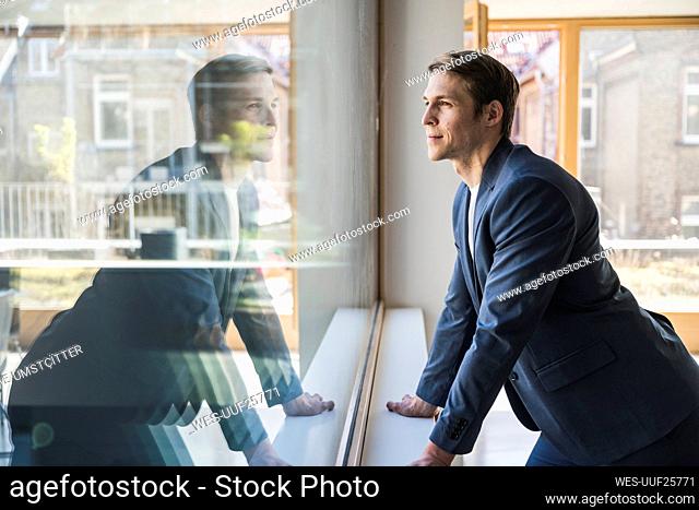 Businessman looking out of window in office