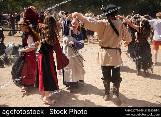 29 July 2022, North Rhine-Westphalia, Cologne: Visitors take part in a dance class at the medieval festival ""Spectaculum 2022""
