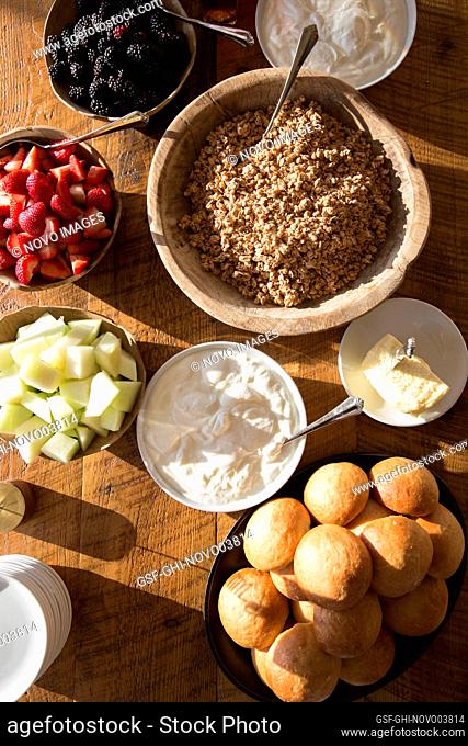 High Angle View of Bowls of Granola, Yogurt and Fresh Fruit on Wood Table