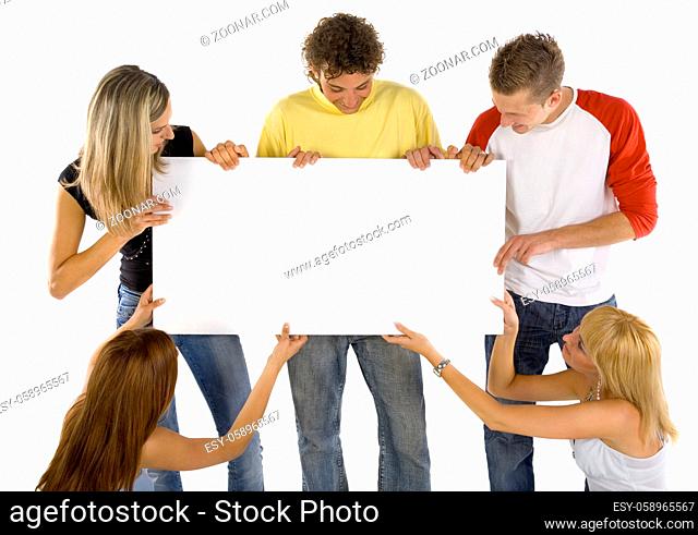 Small group of teenagers holding white blank board. Looking at it. White background, front view