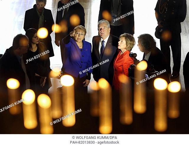 Chilean President Michelle Bachelet (L-R), her German counterpart Joachim Gauck and his partner Daniela Schadt walk through a room lit by candle-like lamps...
