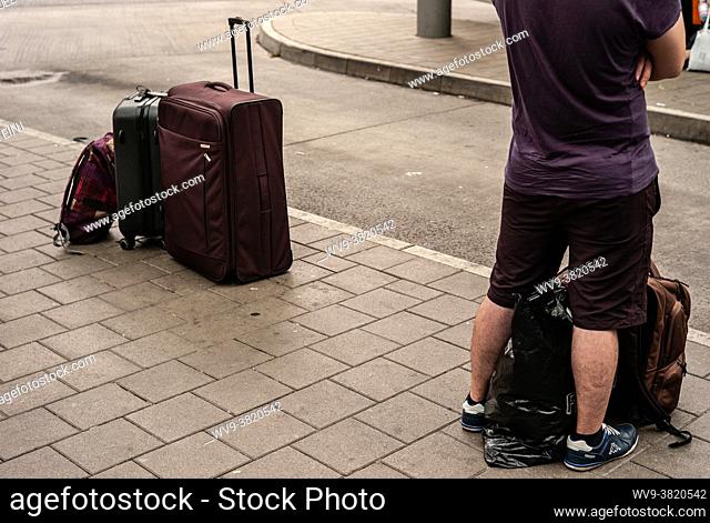 Man waiting for his bus with suitcases in Hamburg, Germany