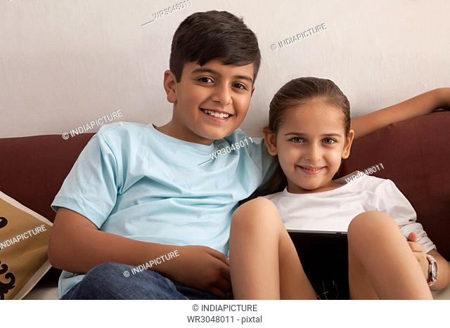Portrait of brother and sister using digital tablet