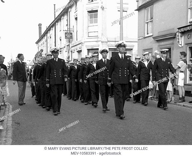 Volunteer officers lead the cadets of TS Wooltan, the sea cadet unit based at Walton-on-the-Naze, Essex. They are marching along the High Street at the head of...