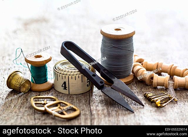 Creative image of seamstress ribbon tools, thimble and scissors for sewing on an old wooden surface. Concept. Selective focus