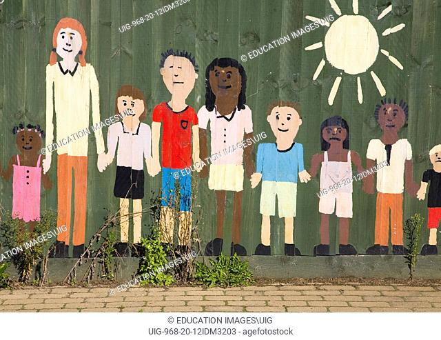 Painted collage picture of young children on a nursery school fence, Wickham Market, Suffolk, England