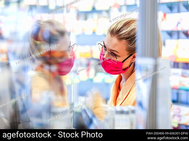 31 March 2020, Saxony, Leipzig: The employee of a pharmacy works with a self-stitched mouthguard. In order to protect the pharmacy's 30-member team from...