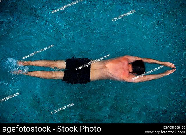Athletic young man swimming in the pool