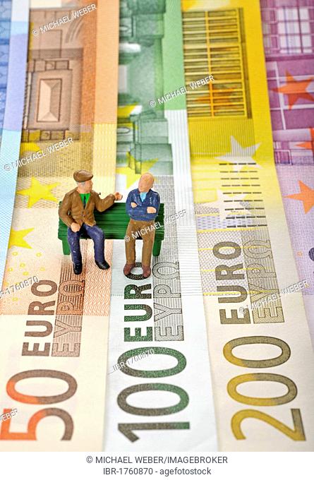 Various euro banknotes with miniature figures of senior citizens on a park bench, symbolic image for pension or retirement