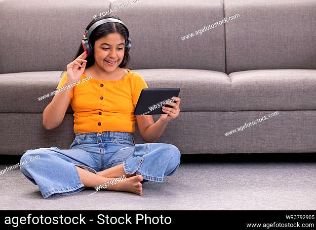 Portrait of a cheerful girl listening to music at home